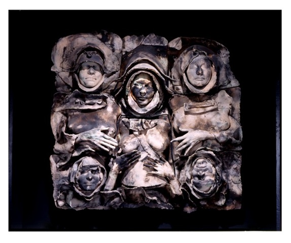 Large wall-hanging piece mostly composed of ghostly and tormented faces of women.